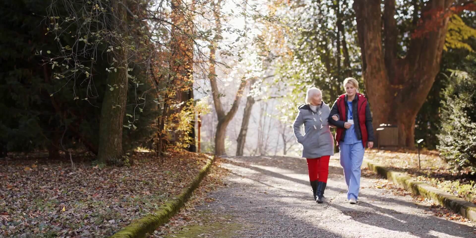 Resources for Cargivers Video caregiver and a senior walking arm in arm down an autumn lane