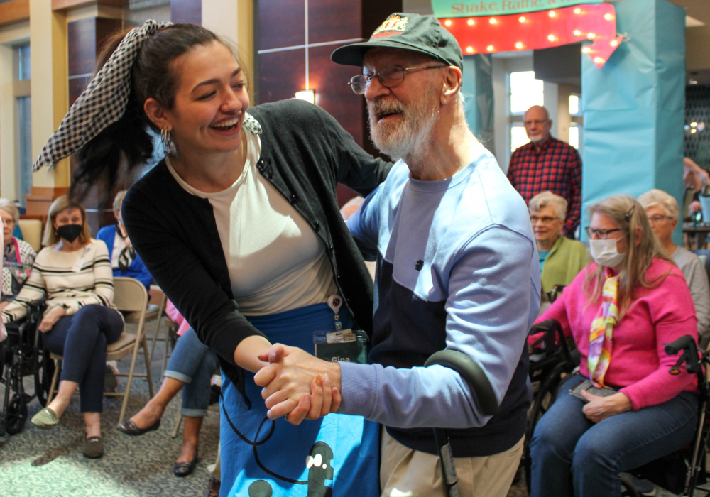 Sock hop young brunette woman dancing with elderly man at sock hop