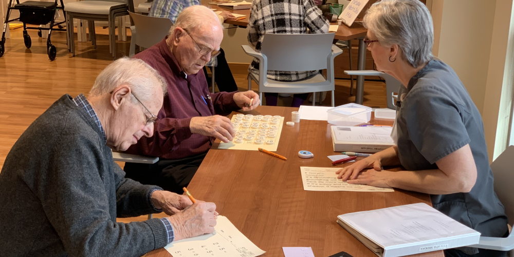 SAIDO_Header_Cropped Two elderly men complete worksheets at a table
