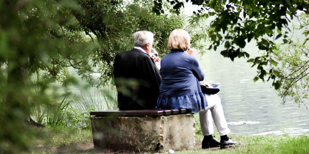 Older couple_Cropped older couple on bench by lake