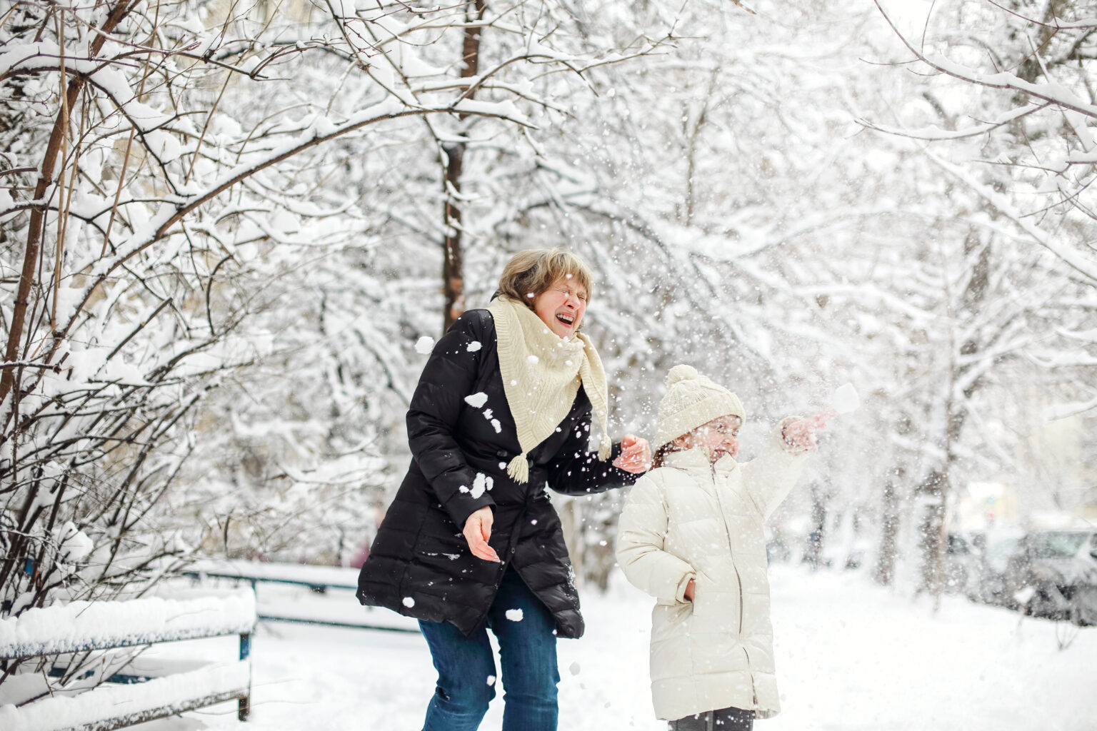 Joyful family grandmother with grandchildren in warm clothes playing outdoors in winter park, enjoying frosty and snowy weather, children actively spending new year holidays in fresh air with grandma Barnabas Foundation Image
