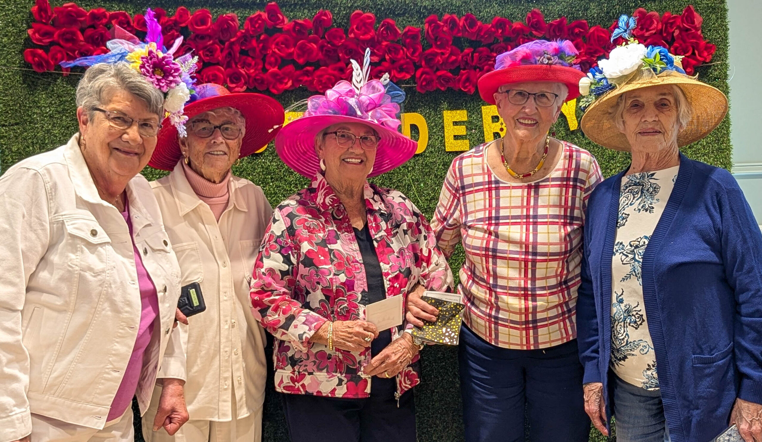 Derby 13 senior ladies with hats standing in front of a grass background